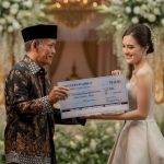 74-year-old Indonesian groom giving a ceremonial check to his 24-year-old bride at a luxury wedding in East Java.