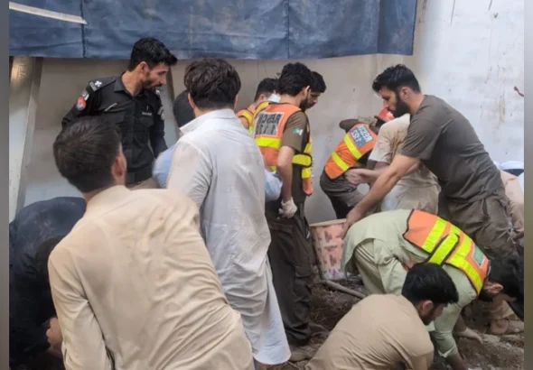 Rescue 1122 and disaster response teams clearing debris at the school roof collapse site in Peshawar